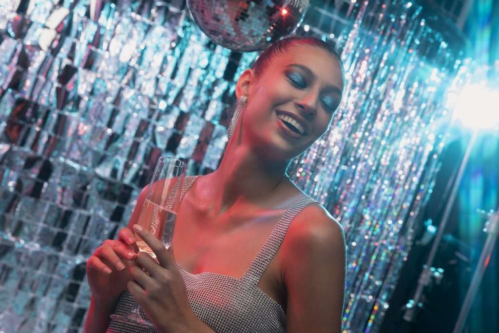 Ragazza immagine sorridente con un calice durante una serata in discoteca